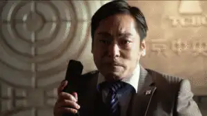 《半澤直樹》中的大和田常務面露猙獰憤怒，猛力將電話筒摔在桌上，隨後憤而起立並將辦公桌上的物品暴力掃落。