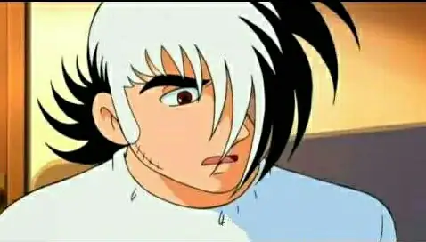 黑白相間頭髮的男性角色，左臉頰有疤痕，眼神驚訝，嘴巴微張。出自《怪醫黑傑克》。