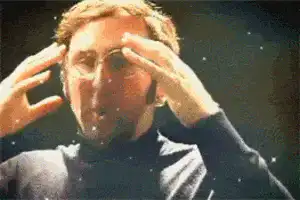 戴著眼鏡的男子將雙手自太陽穴向外移開，其頭部隨之爆發宇宙星系大爆炸的特效，神情顯得極度震撼。出自喜劇節目《提姆和艾瑞克超棒秀，讚啦！》。